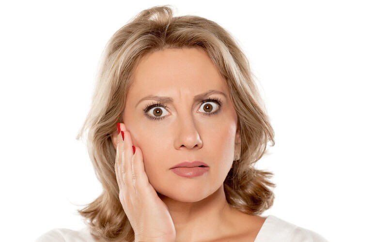 woman holding mouth experiencing tooth pain