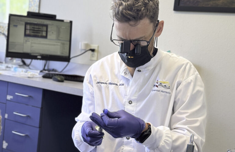 Dentist examining a dental model while planning cosmetic treatment and smile analysis