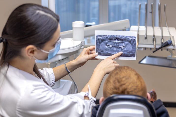 Dentist showing a dental X-ray to a patient.